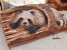 Raccoon in Log Chainsaw Carving